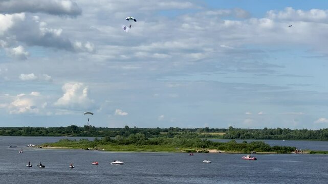 A group of people are enjoying a day on the water, with a few of them parasailing