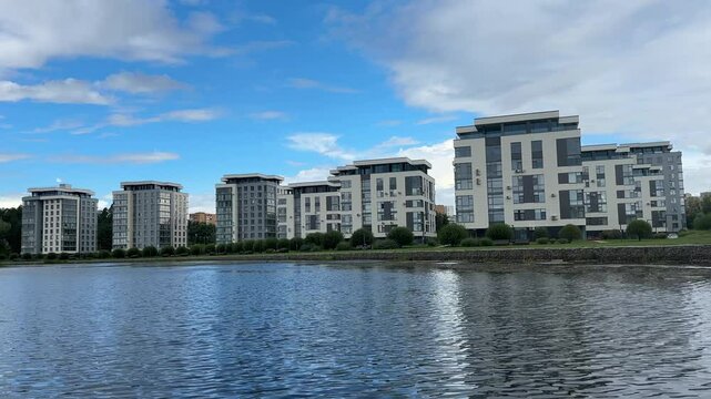 A large building with a lot of windows is reflected in the water. Views of the city of Sarov, Nizhny Novgorod region.