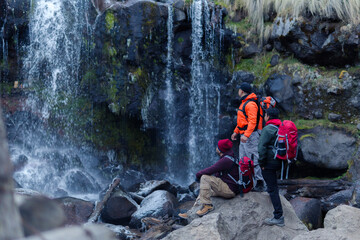 Hikers admiring apatlaco waterfalls near iztaccihuatl and popocatepetl volcanoes