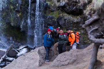 Hikers taking selfie in front of apatlaco waterfall with iztaccihuatl and popocatepetl volcanoes