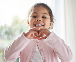 Girl, child and heart hands in home portrait, love symbol and sign for kindness or peace in lounge....
