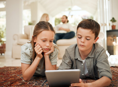 Children, tablet or relax on floor for media, streaming or playing games in home. Siblings, tech or watching videos in living room for entertainment, peace or parents on sofa for childcare on weekend