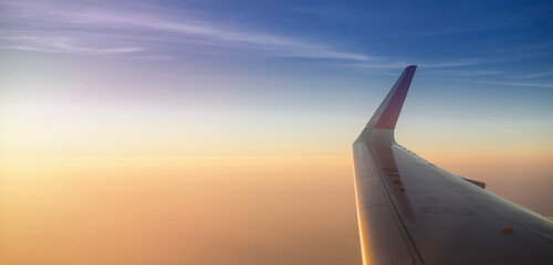 Obraz premium travel by plane, view of sunset from the window of a plane over chaina. The sky is pastel colors moods relaxing and enjoying the fact of flying.