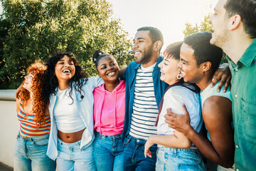 Diverse group of friends have fun outdoors. Young people hang out on city street. Youth culture and community concept