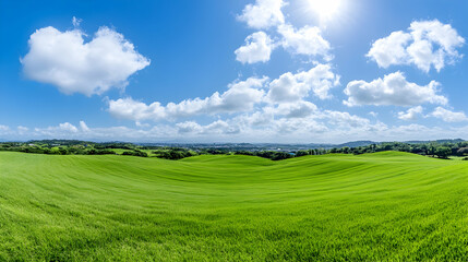 Fototapeta premium Panoramic view of rolling green hills under a vibrant blue sky with fluffy white clouds