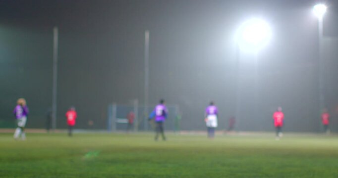 The scene shows eager young soccer players practicing on a lush green field, surrounded by colorful cones, all illuminated by warm evening light, creating an inviting atmosphere