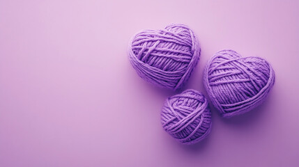 Three purple yarn hearts on lavender background.