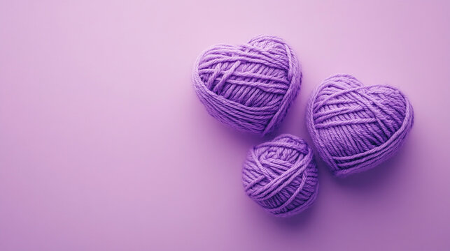 Three purple yarn hearts on lavender background.