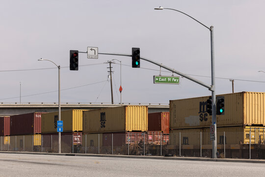 Compton, California, USA - April 2, 2025: An intermodal stack freight train loaded with containers passes towards the port of Los Angeles.