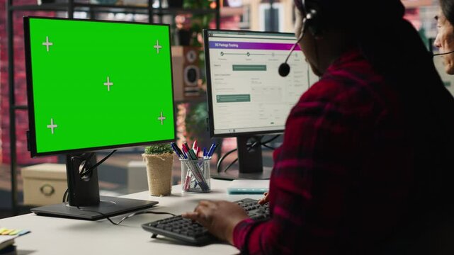 Call center agents tracking shipments in office using green screen computer. Customer center workers use chroma key PC to locate clients packages and provide status updates, camera A
