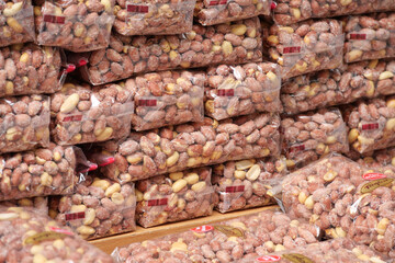 Bags of assorted nuts displayed in a market for sale