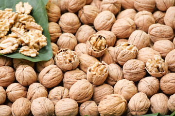 Walnuts and walnut shells displayed at a market in warm sunlight