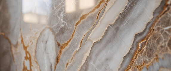 Detailed close-up of elegant marble texture with layered beige, grey, and white bands, highlighted by gold and mineral veining  
