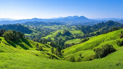 Fototapeta premium Serene Panoramic View of Rolling Green Hills and Mountains Under a Clear Blue Sky