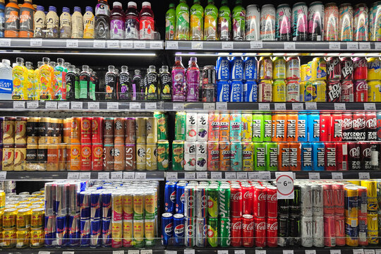 Penang, Malaysia - Mar 26, 2025: A wide variety of colorful canned and bottled drinks including soda, energy drinks, flavored water, and coffee displayed in a refrigerated section at Mercato Grocery.