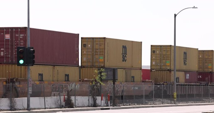 Compton, California, USA - April 2, 2025: An intermodal stack freight train loaded with containers passes towards the port of Los Angeles.