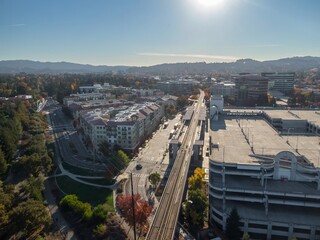 Aerial view of Walnut Creek, California, USA, showcasing the BART station, parking structure, and surrounding buildings. The photo highlights urban planning and transportation infrastructure.