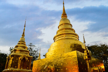 Fototapeta premium Golden Pagoda, Lanna Architecture, Symbols of Buddhism, South East Asia at Phra Singh Woramahaviharn Temple, Chiang Mai, Northern Thailand