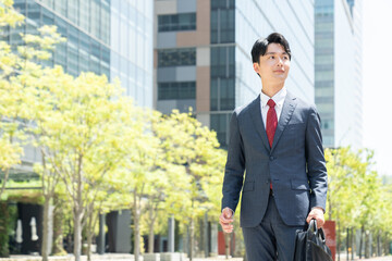オフィス街を歩く若いビジネスマン