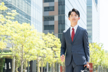 オフィス街を歩く若いビジネスマン