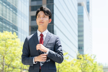 オフィス街に立つ若いビジネスマン