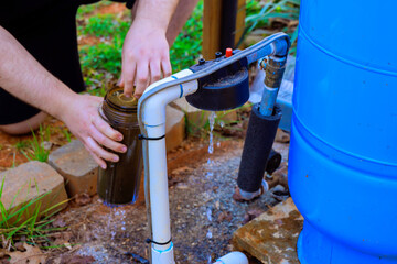 Individual changing filter water from water filtration system, showcasing sustainability in an...