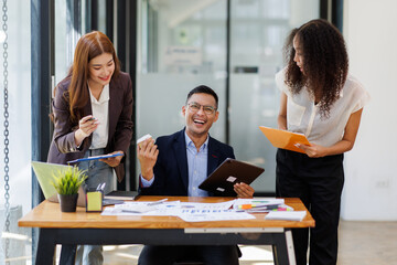 Group of confident business people point to graphs and charts to analyze market data, balance sheet, account, net profit to plan new sales strategies to increase production capacity.	
