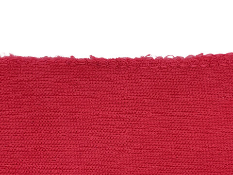 A close-up image of a textured red fabric edge against a black background, showcasing intricate weaving patterns and vibrant color.