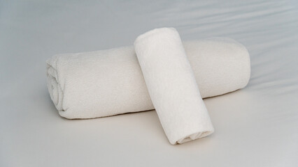 White towel rolled up on the bed. Beautiful layout for a resort welcome.