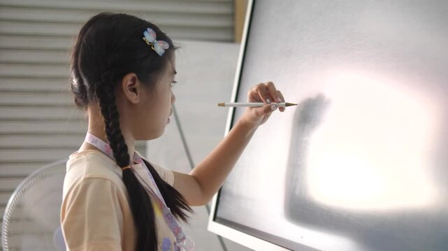 Southeast Asian Girl Writing on Digital Board During Tutoring Session &ndash; Modern Learning and Education Technology Concept