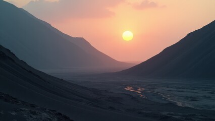 Desert valley with winding stream at sunset between silhouetted hills	