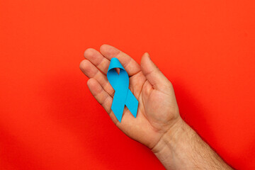 Support for cancer awareness through symbolic blue ribbon on bright background