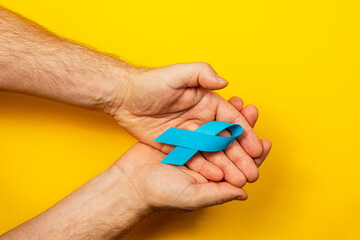 Support cancer awareness with symbolic blue ribbon on yellow background