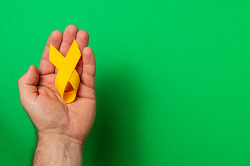 Support for awareness in cancer treatment with yellow ribbon symbol