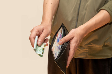 A person handing over a bill, taking it out of their wallet for payment or financial transaction....