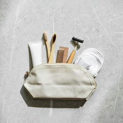 Sustainable self-care items top view, bamboo toothbrushes, comb, toothpaste in white tube, reusable...