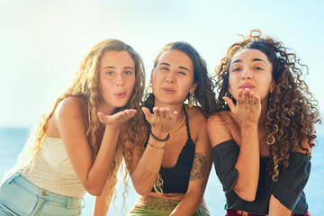 Fototapeta premium Girl, friends and blow kiss on vacation, portrait and happy with bonding, connection or memory in summer. Women, people and group with smile for symbol, icon or sign for holiday at beach in Italy