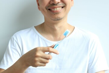 Man holding toothbrush in hand, health concept