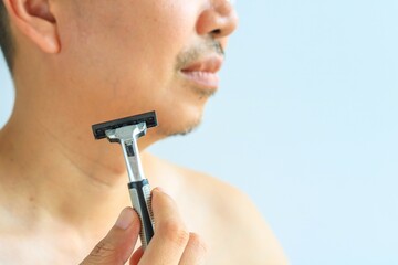 Man holding a regular razor, health concept
