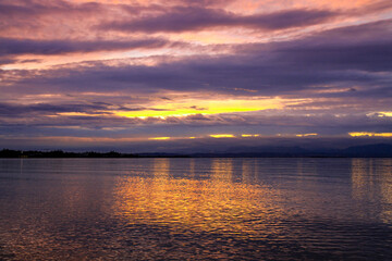 Naklejka premium Golden reflection of sunset over a calm lake.
