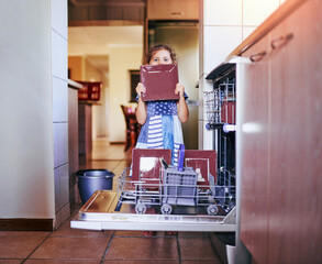 Home, kitchen and portrait of child by dishwasher for hygiene, responsibility and learning to clean. Shy, girl and face with plate by electrical appliance for packing, life skills and weekend chores