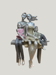  figurine of a young family sitting on a bench