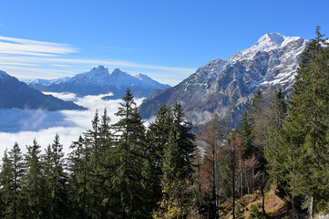 Obraz premium Fall mountain landscape, blue sky, sun shines above the fog in the valley, first snow. Background the mountains Buchstein and Reichenstein. Styria, Austria.