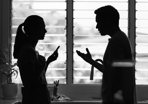 Couple sitting at home talking, having conversation. People discussing domestic issues, argument, working out problems.	