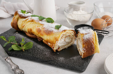 Finnish pancake in the roll cake with cream on white background