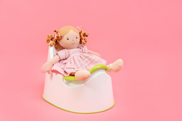 A child's toy sits on a potty on an isolated background, potty training
