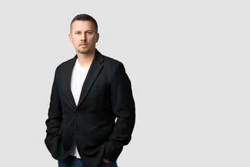 Casual Business Portrait of a Man in a blazer and white t-shirt on a gray background with copy space