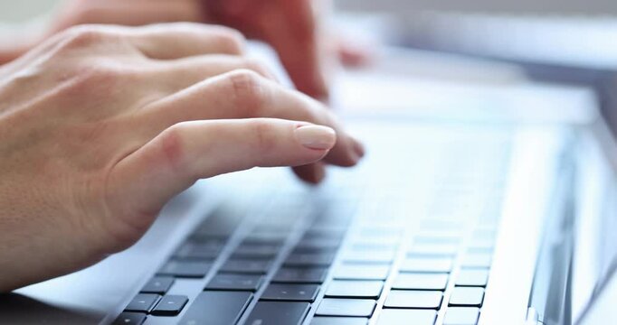 Woman office worker types important report on laptop keyboard. Businesswoman enters data into paper and formats document properly. Slow motion