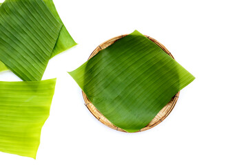 Banana leaves in bamboo weave plate on white background.