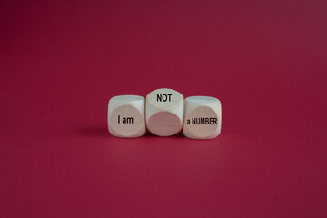 Wooden cubes form the expression I am not a number. Beautiful red background. Business your opinion matters concept.
